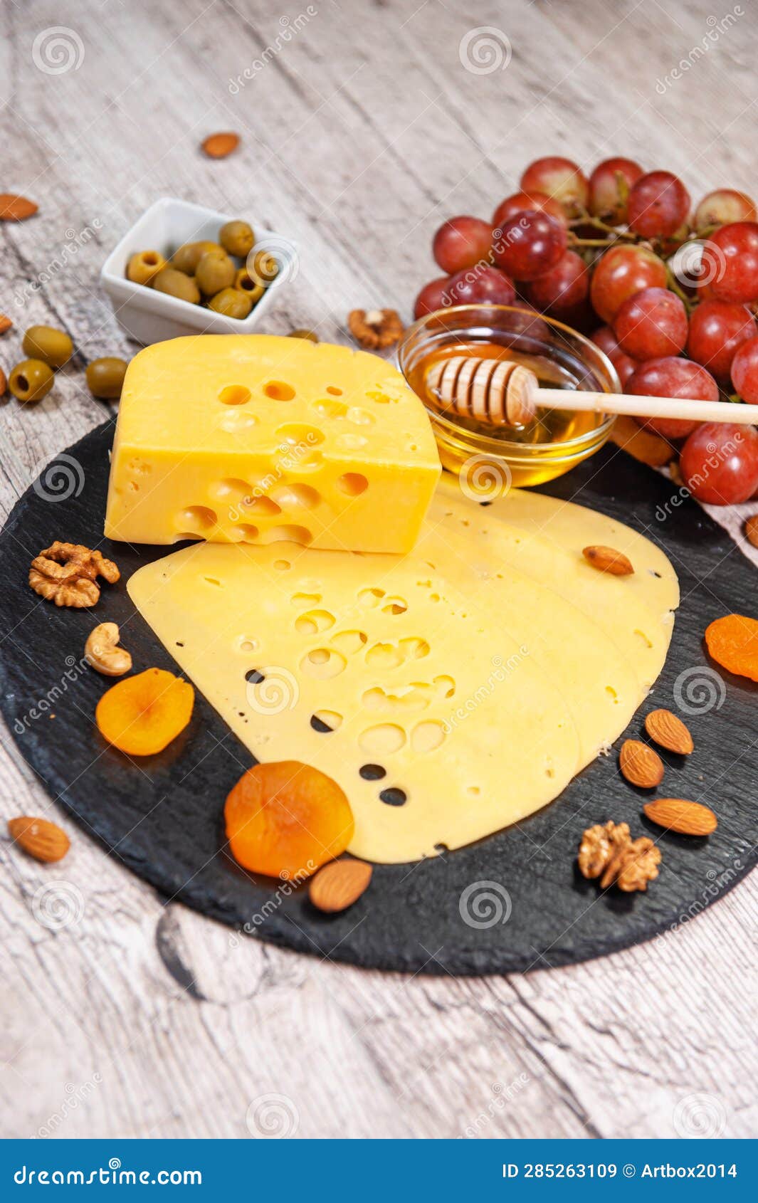Maasdam Cheese with Dried Apricots, Nuts and Honey on a Graphite Board