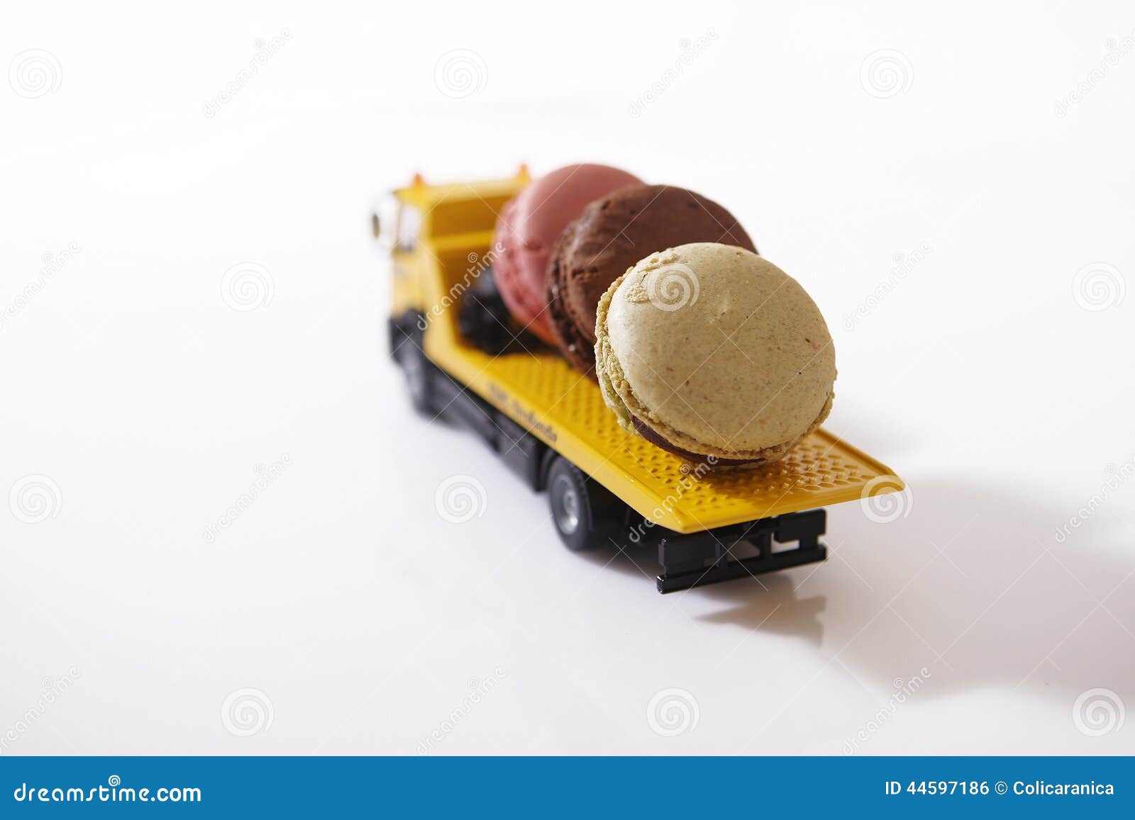 Macarons en un coche miniatura. Coche miniatura que lleva tres macarons