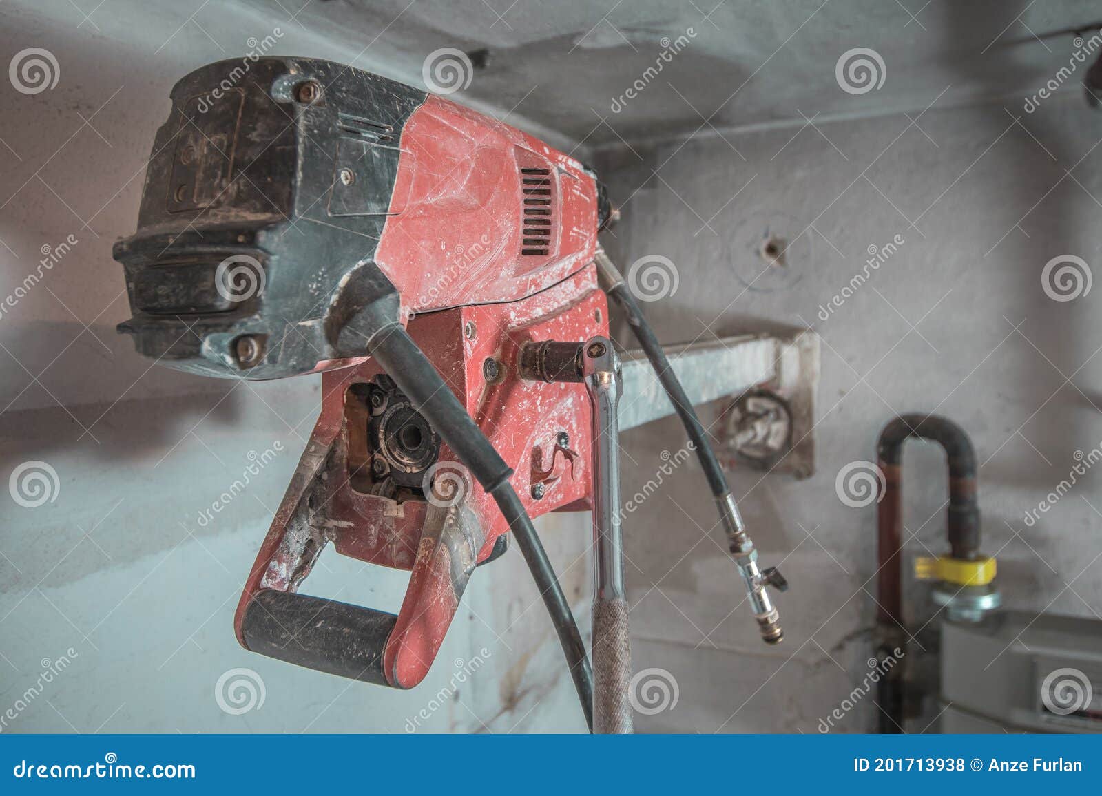 machine for drilling holes in hthe concrete wall. red professional drill for making holes in the walls. back view