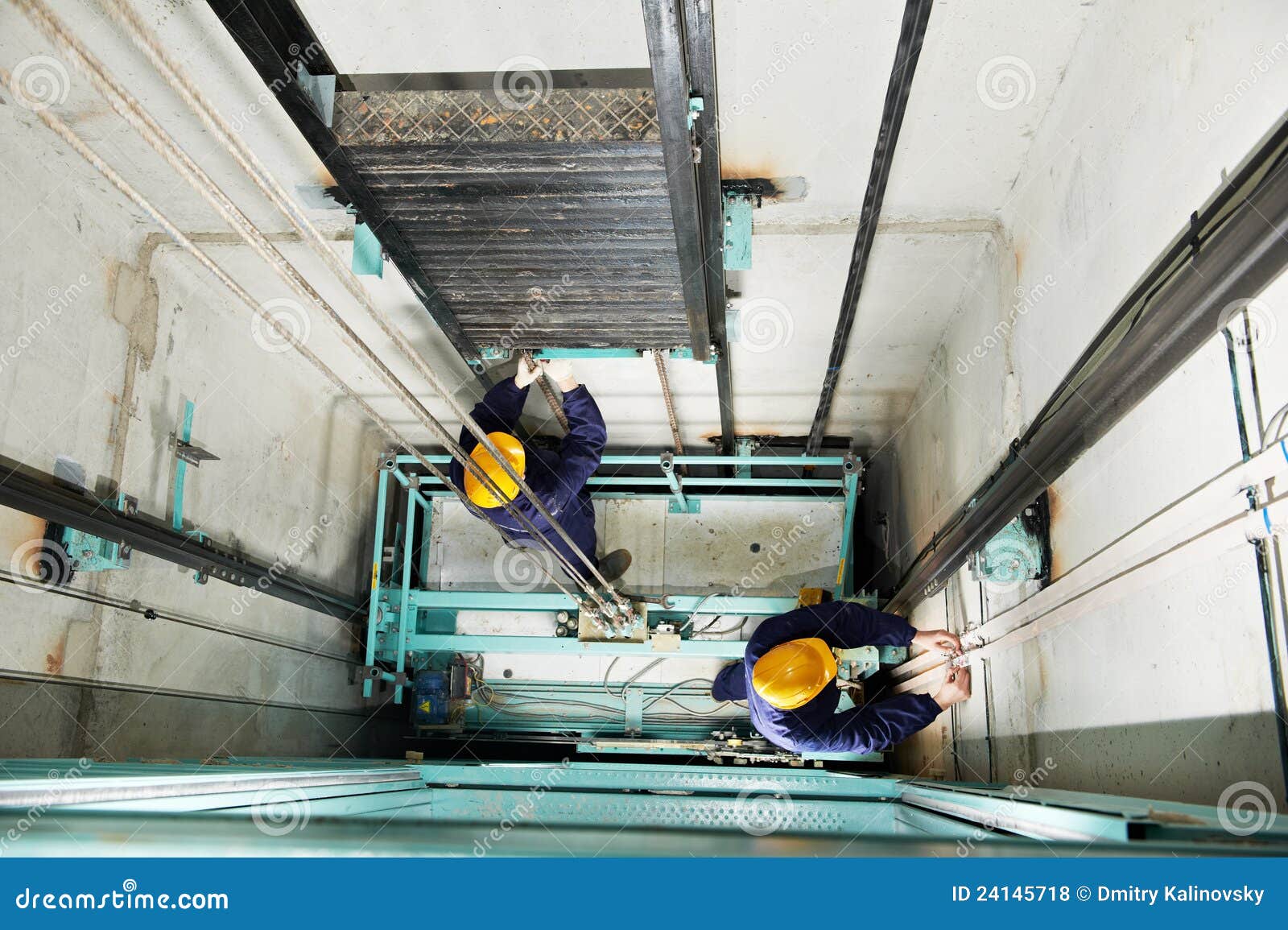 machinists adjusting lift in elevator hoistway