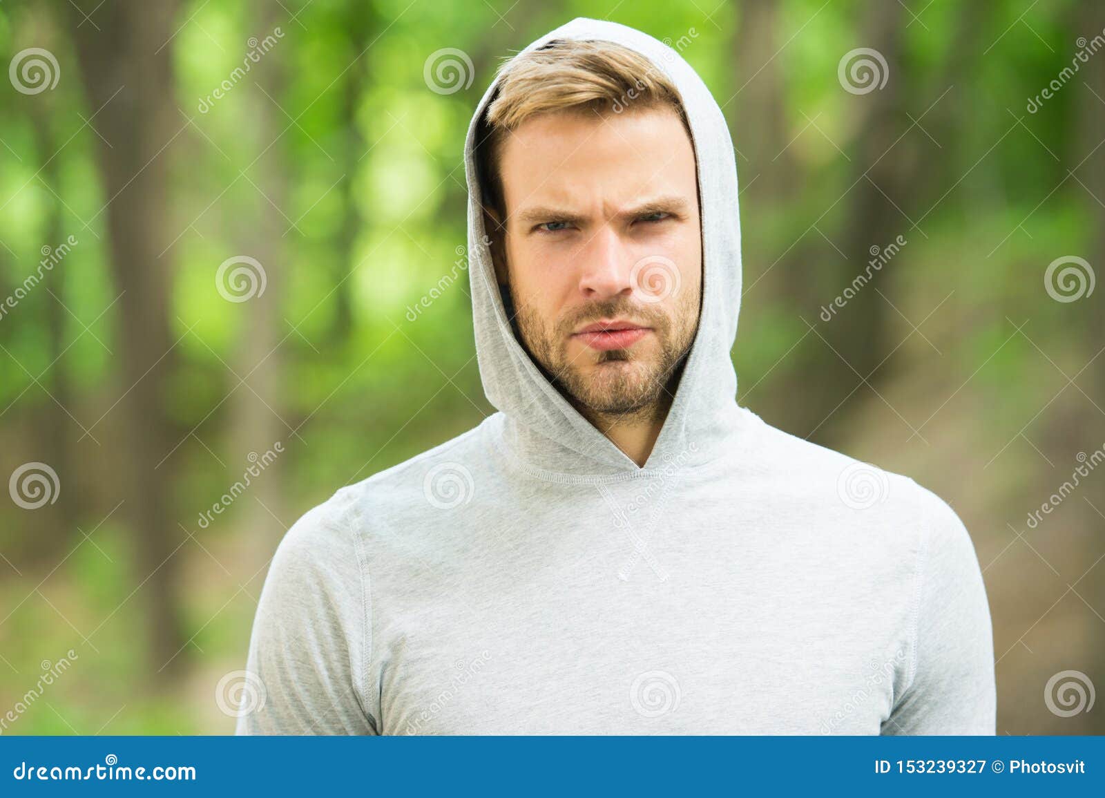 macho man. man in hood. casual style. male fashion. unshaven guy outdoor. seriousness and masculinity. sportswear