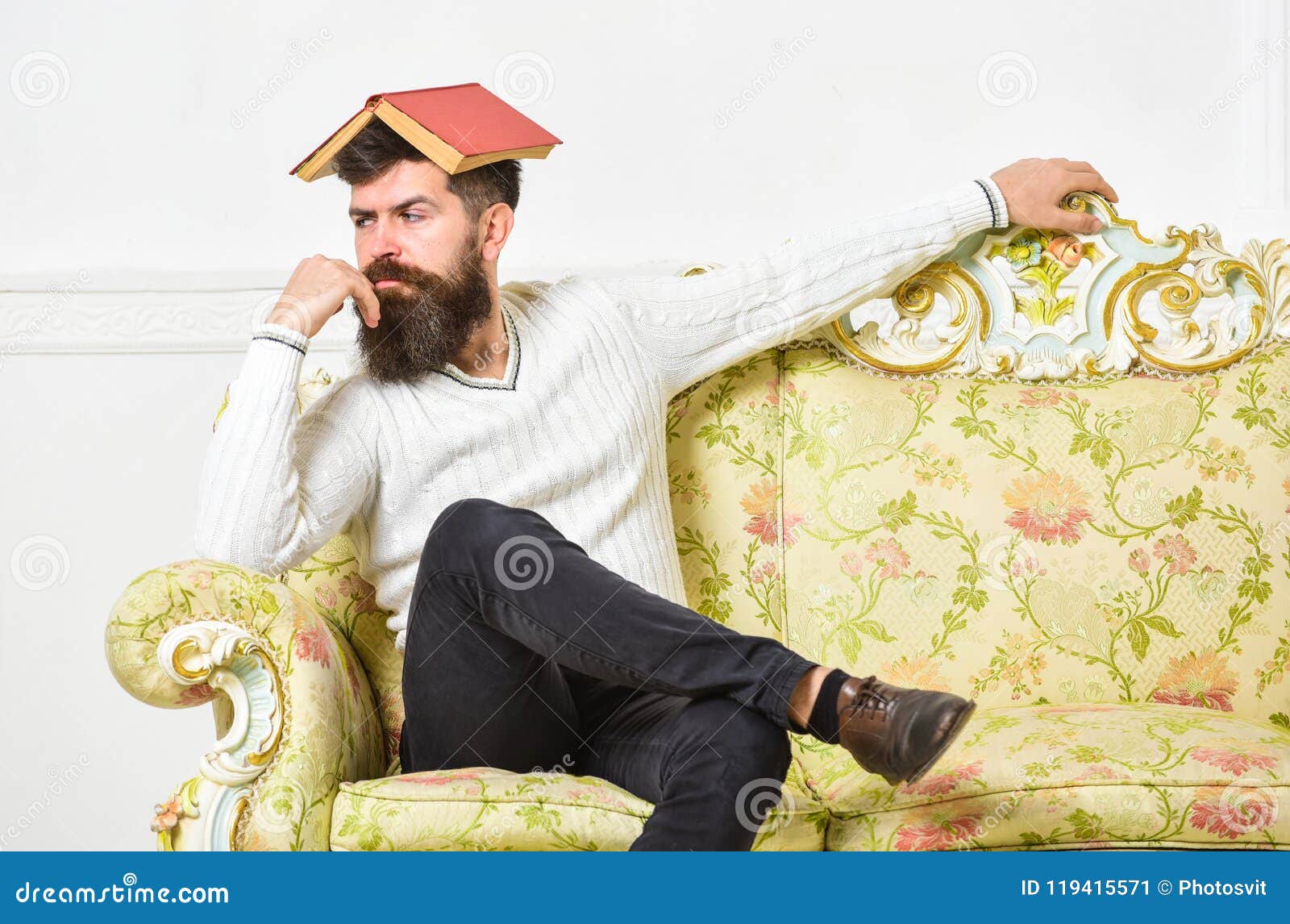 macho sits with open book on head, like roof. boring literature concept. guy bored, fed up of reading old boring book