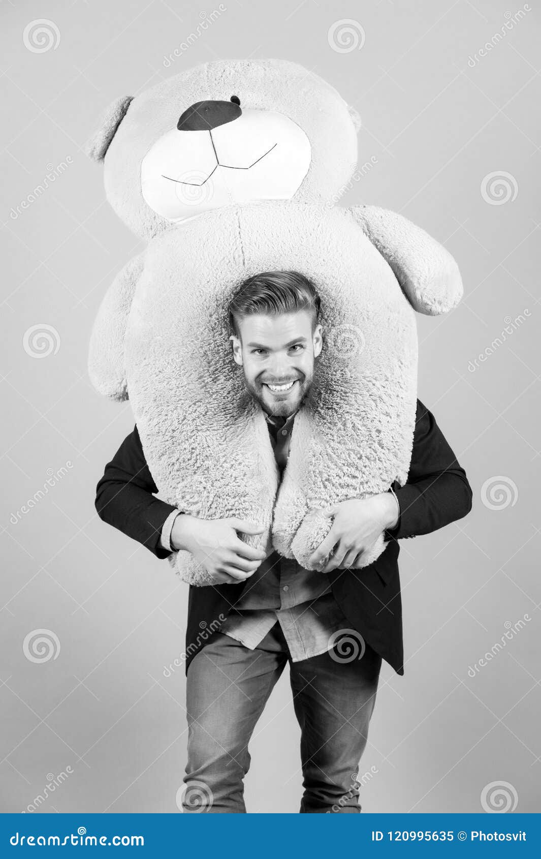 macho smiling with big animal toy, present