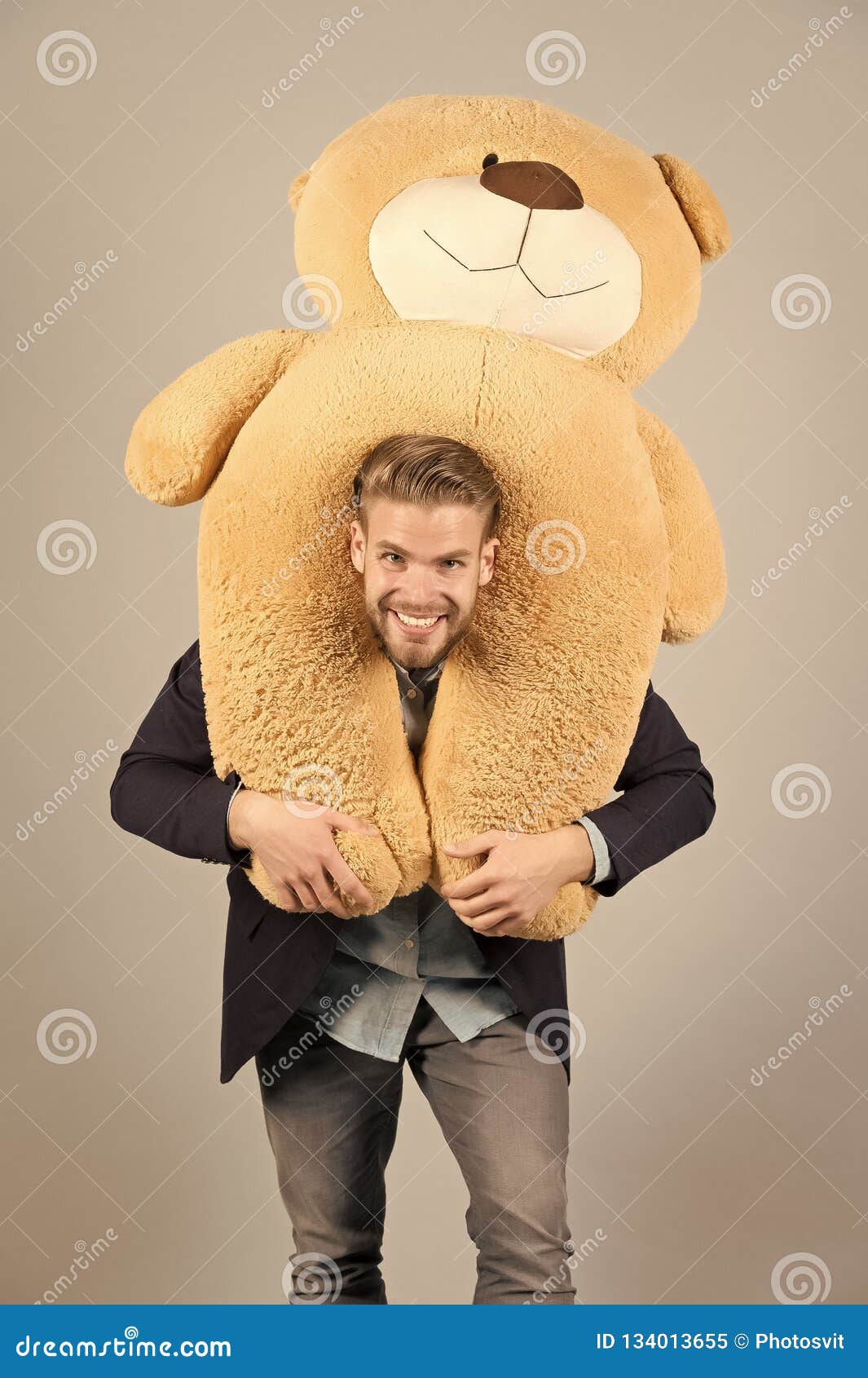 macho smiling with big animal toy, present