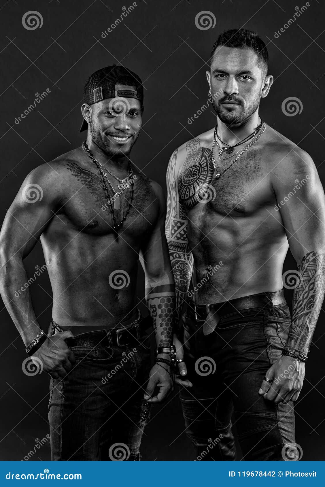 machos with muscular tattooed torsos look attractive, dark background. guys sportsmen with muscular torsos.