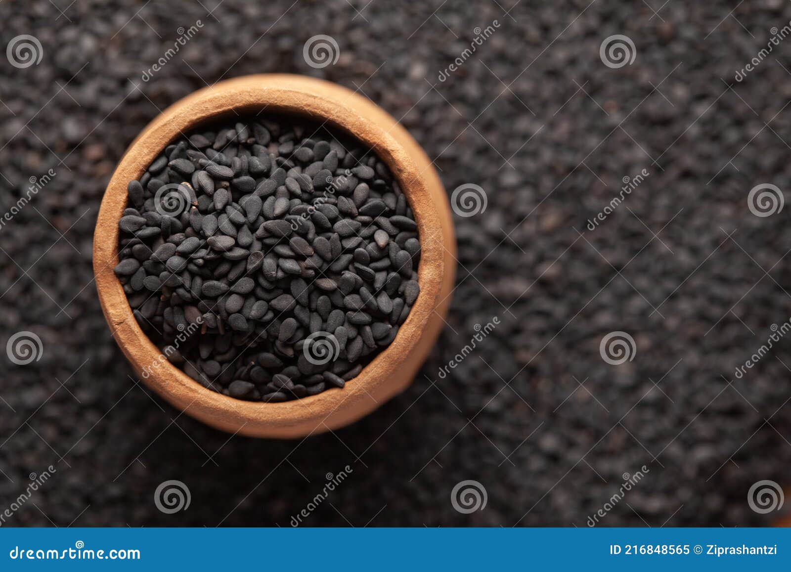 macro close-up of organic black sesame seeds sesamum indicum or black til with shell in an earthen clay pot kulhar