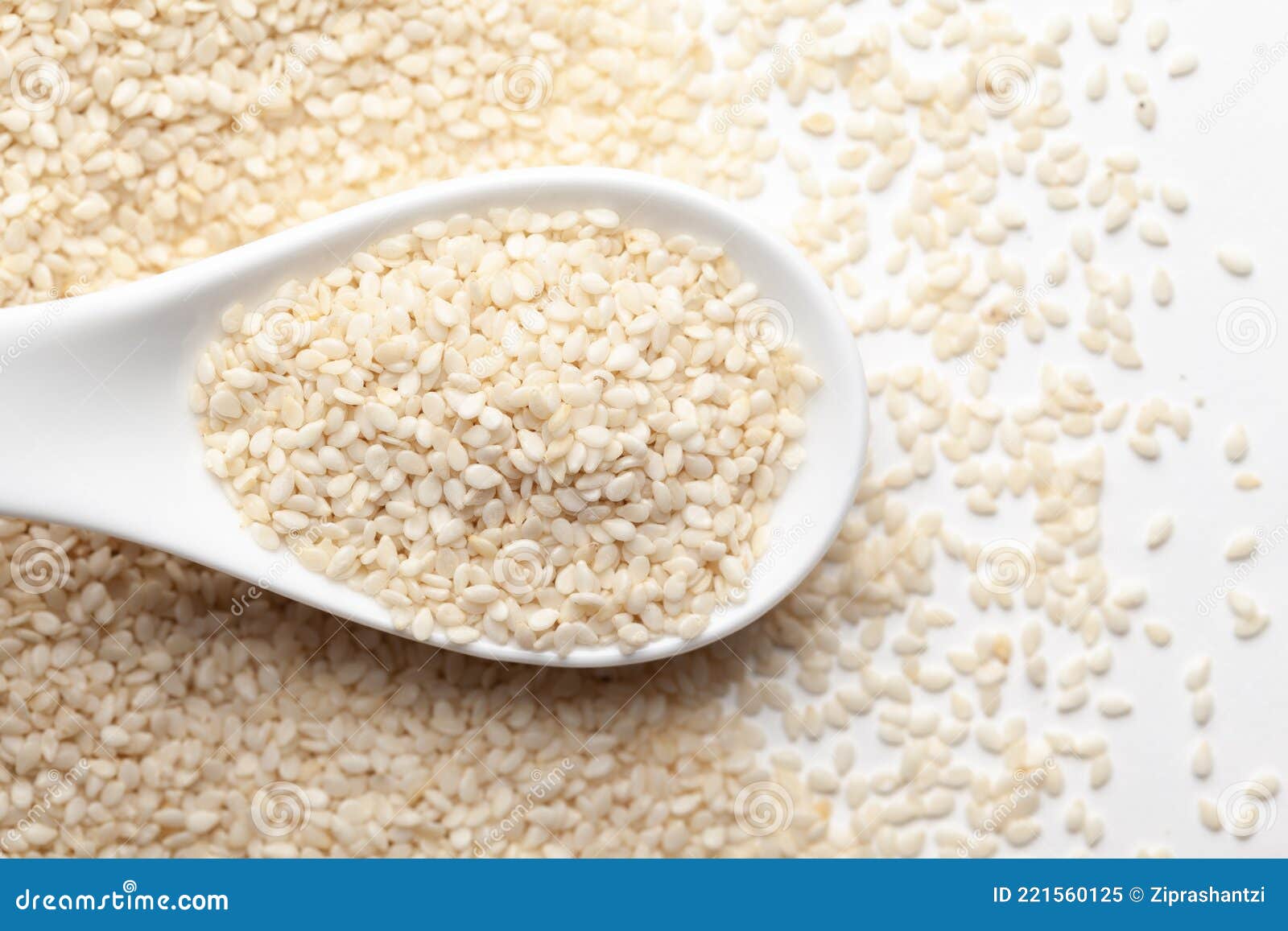 macro close up of organic white  sesame seedssesamum indicum polished or white til without the shell on a white ceramic soup