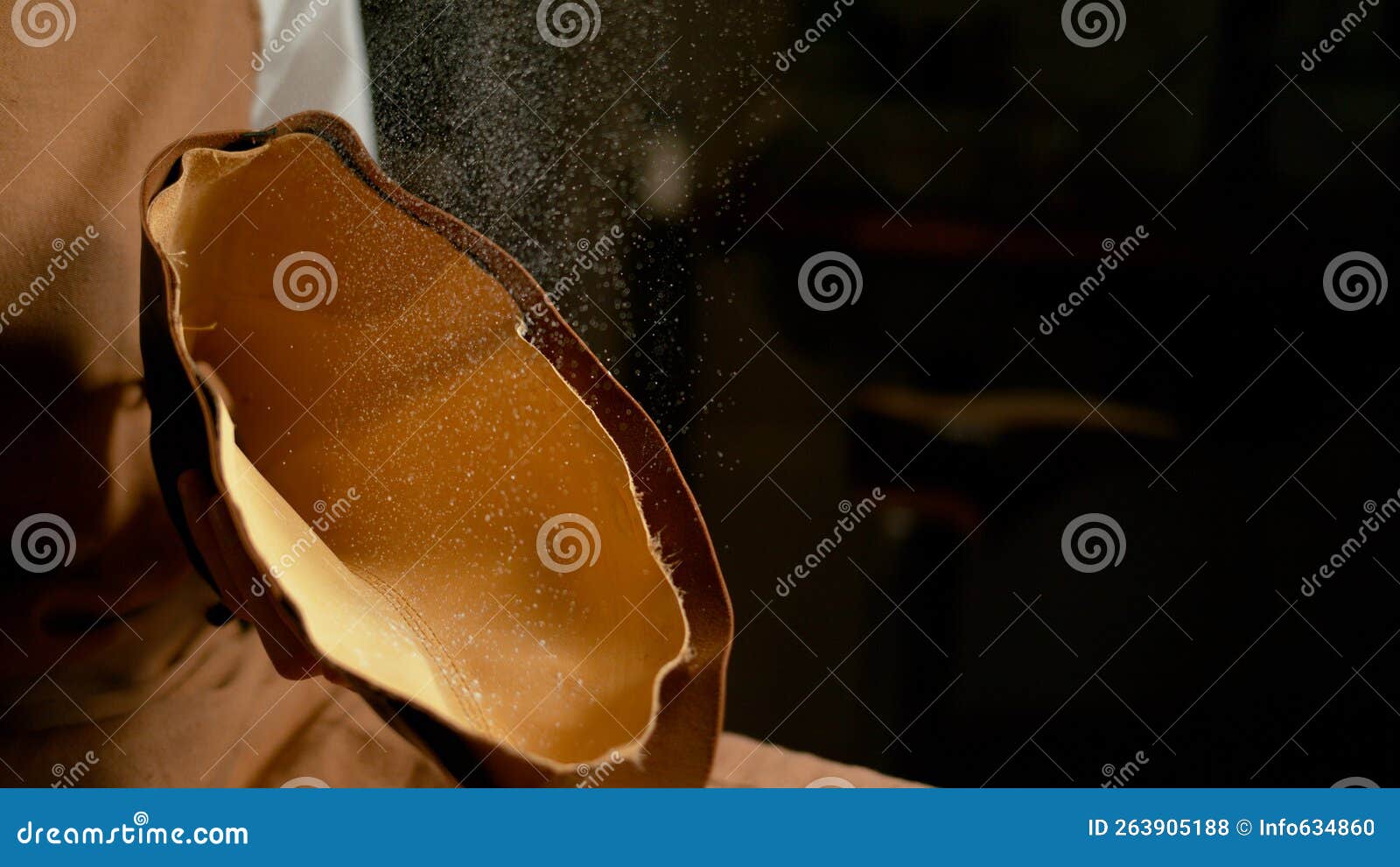 macro: cobbler powdering the textile insole of a new handmade shoe in the making