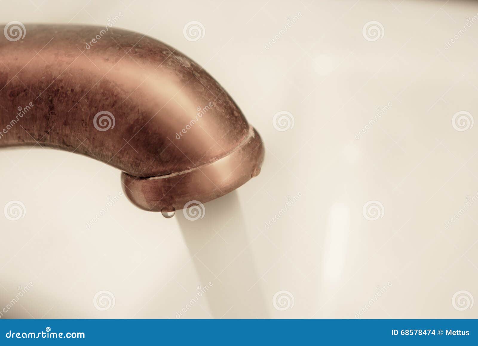 macro of copper water tap with flow of water going out