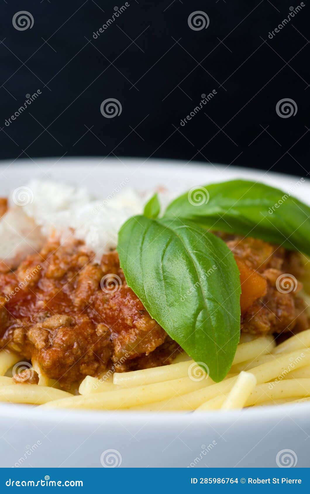 Macro Image of Spaghetti with Meat Sauce and Basil on Black Background