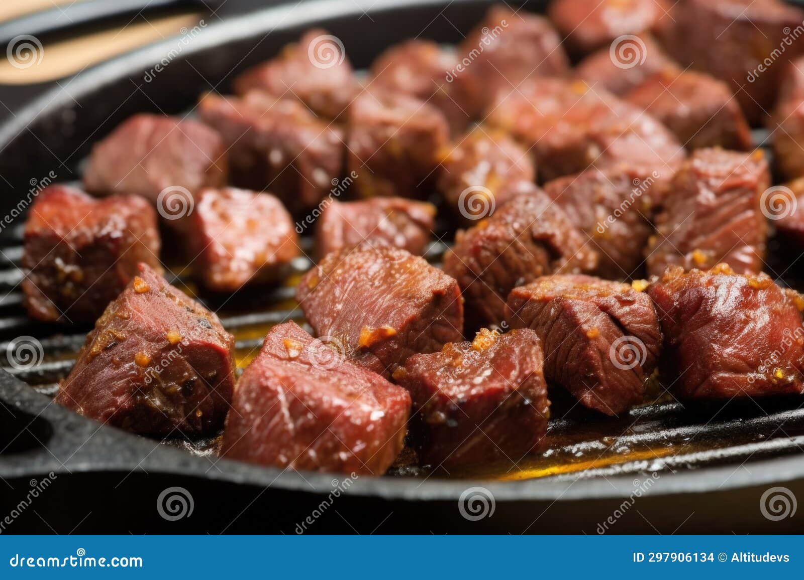 Macro Shot of Garlic Bbq Steak Tips on Cast Iron Grill Pan Stock Photo