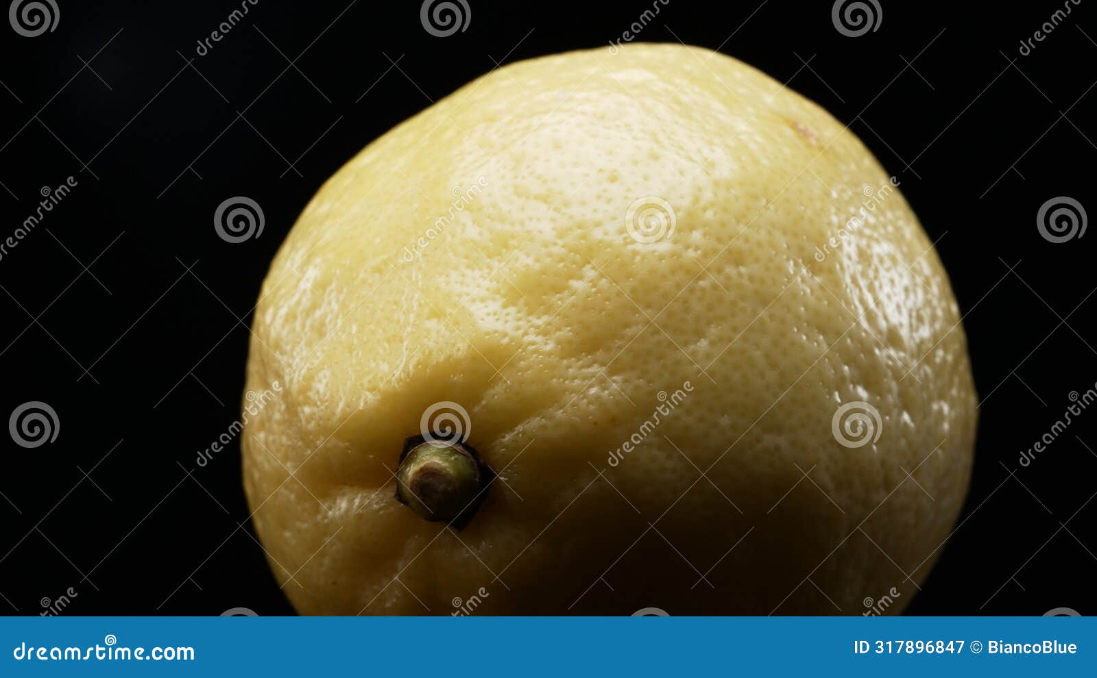 macrography of a lemon against a bold black background. close up. comestible.
