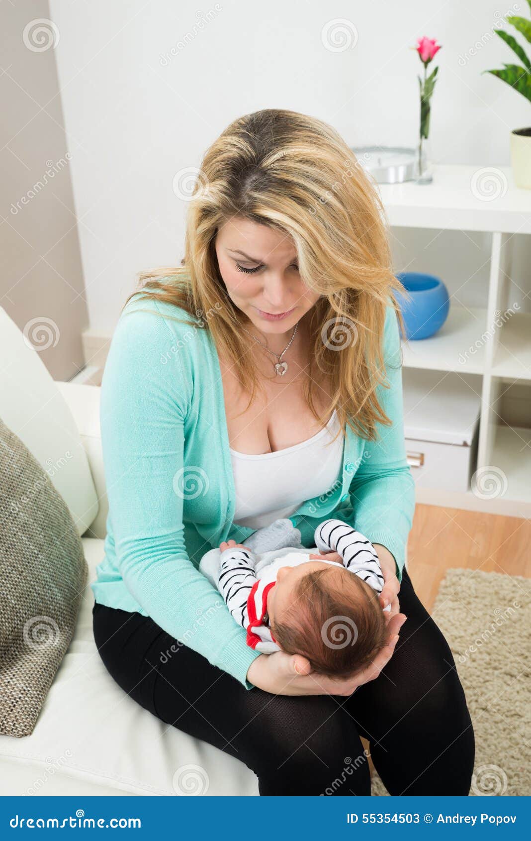 Madre con il bambino. Madre sollecitata su Sofa With Carrying Baby