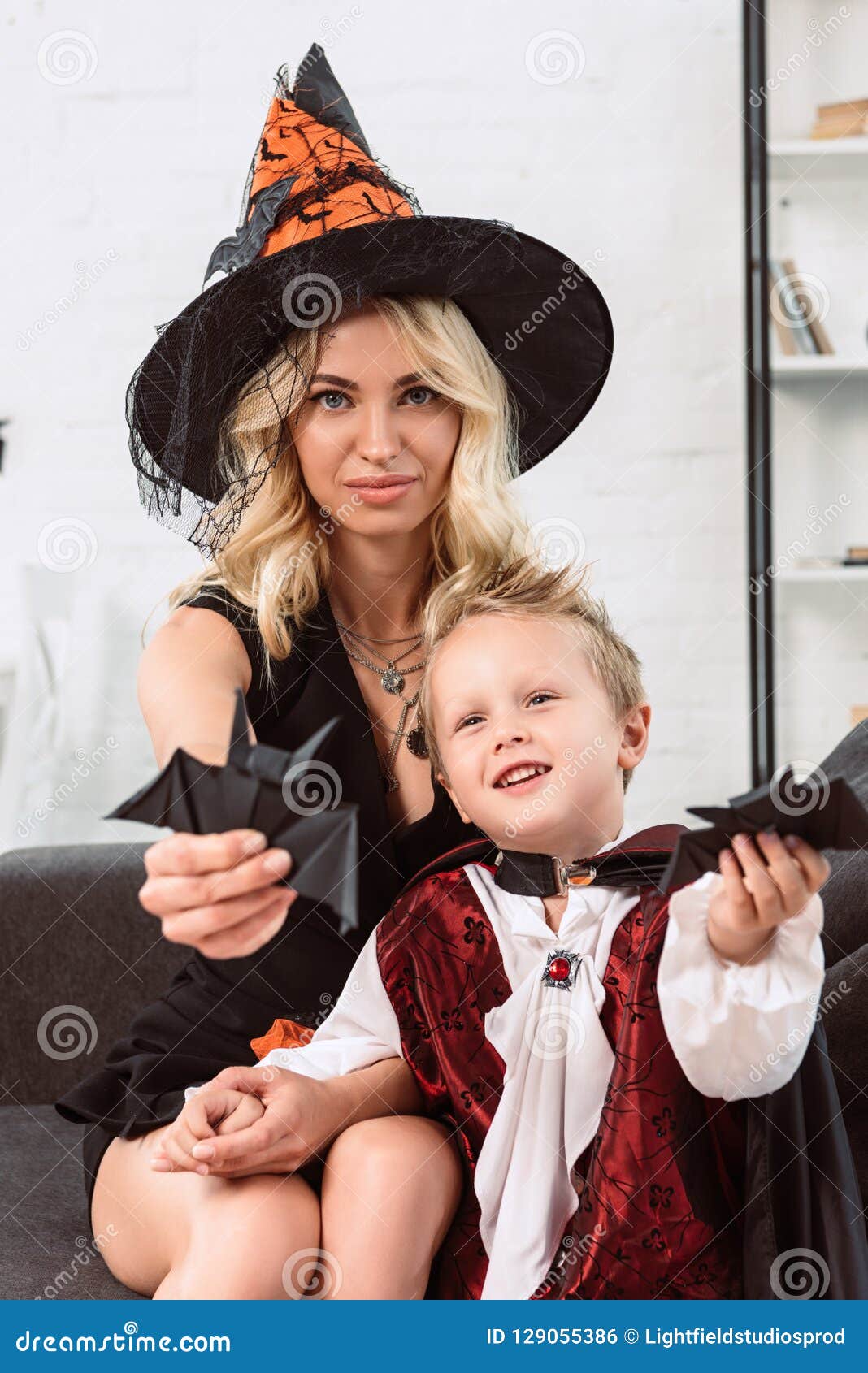 Madre E Piccolo Figlio in Costumi Di Halloween Che Mostrano I Pipistrelli Di  Carta Neri Sul Sofà Fotografia Stock - Immagine di carino, spaventoso:  129055386
