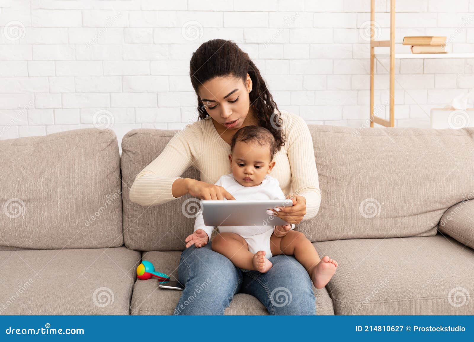 Madre Negra Con Bebe Usando La Tableta Viendo Dibujos Animados En El Interior Imagen De Archivo Imagen De Dormitorio Maternidad