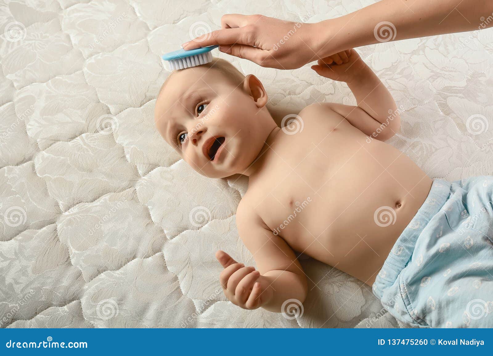 Cepillo para el cabello y cuidado del bebé. madre peinando el cabello recién  nacido