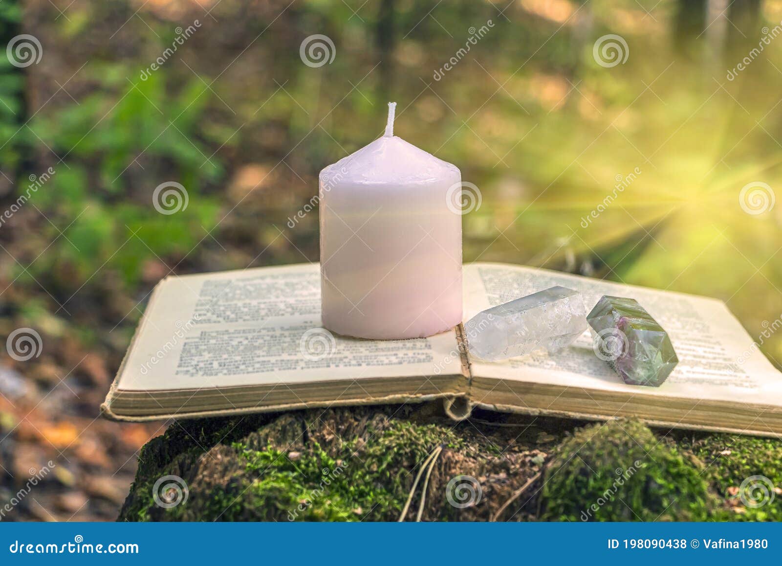 magic still life with fluorite, quartz crystal, candle and old book. rocks for mystic ritual, witchcraft wiccan or spiritual