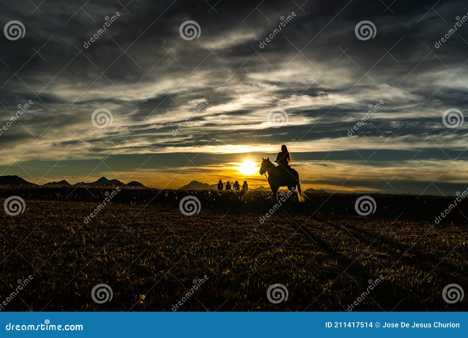 the woman is riding the horse at sunset.