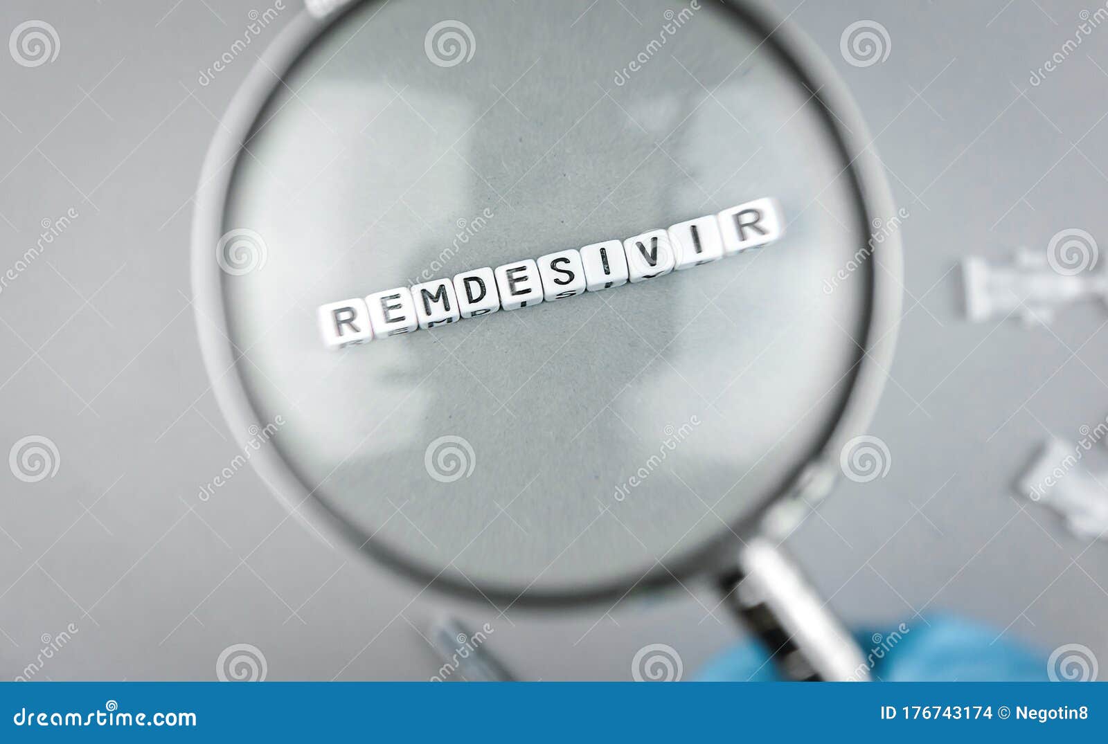 magnifying glass on alphabet dices with the word remdesivir a possible treatment for corona virus