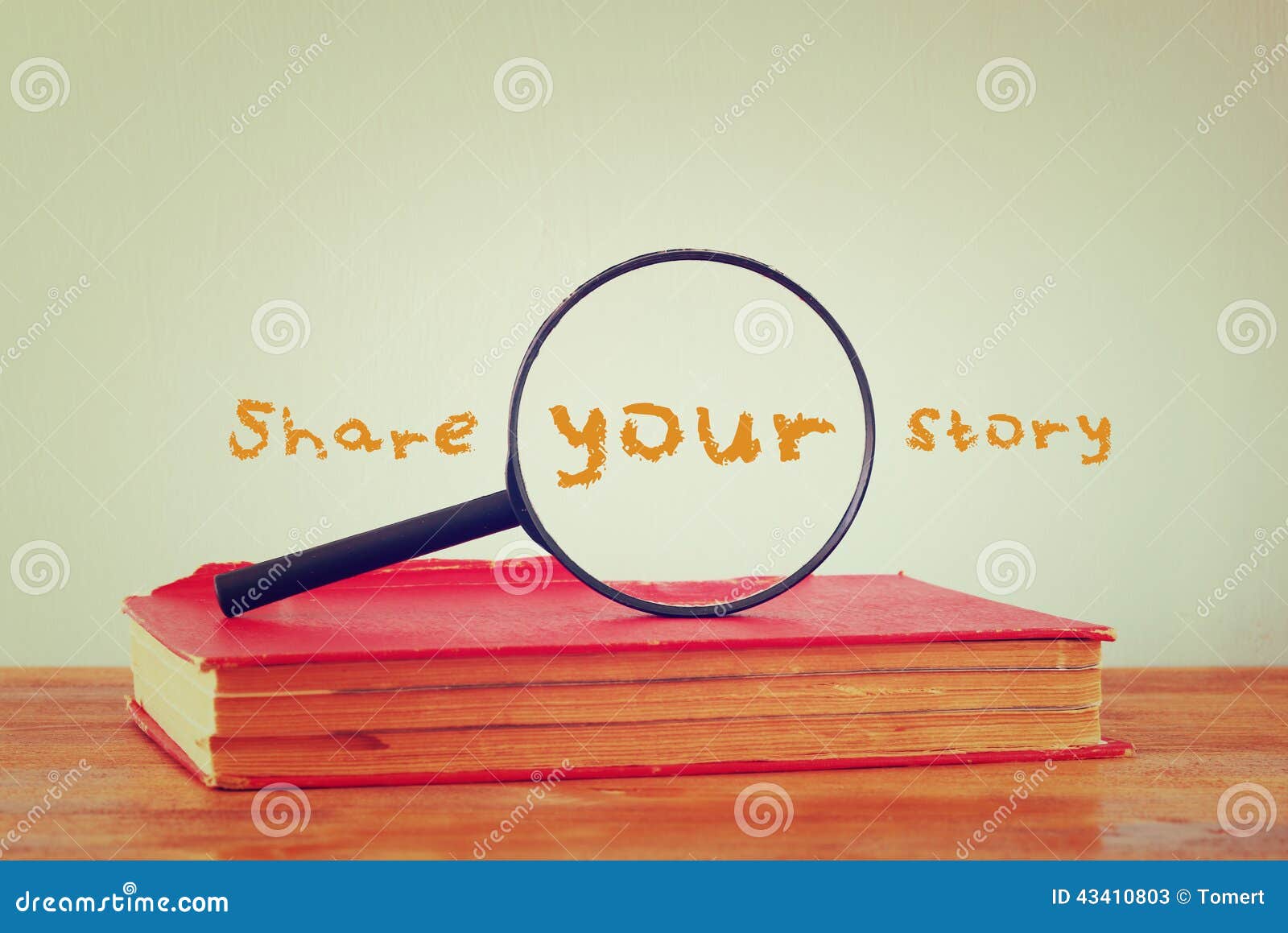 Magnifying glass , old book with the phrase share your story. filtered image.