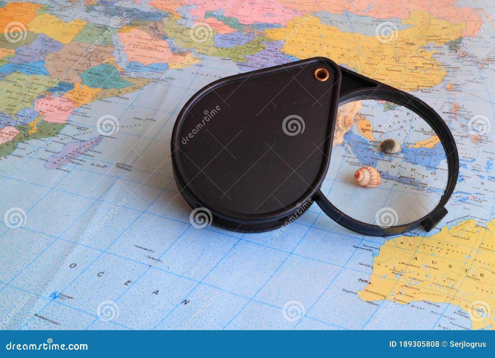 A Magnifying Glass for Reading and a Geographic Map Stock Photo Image