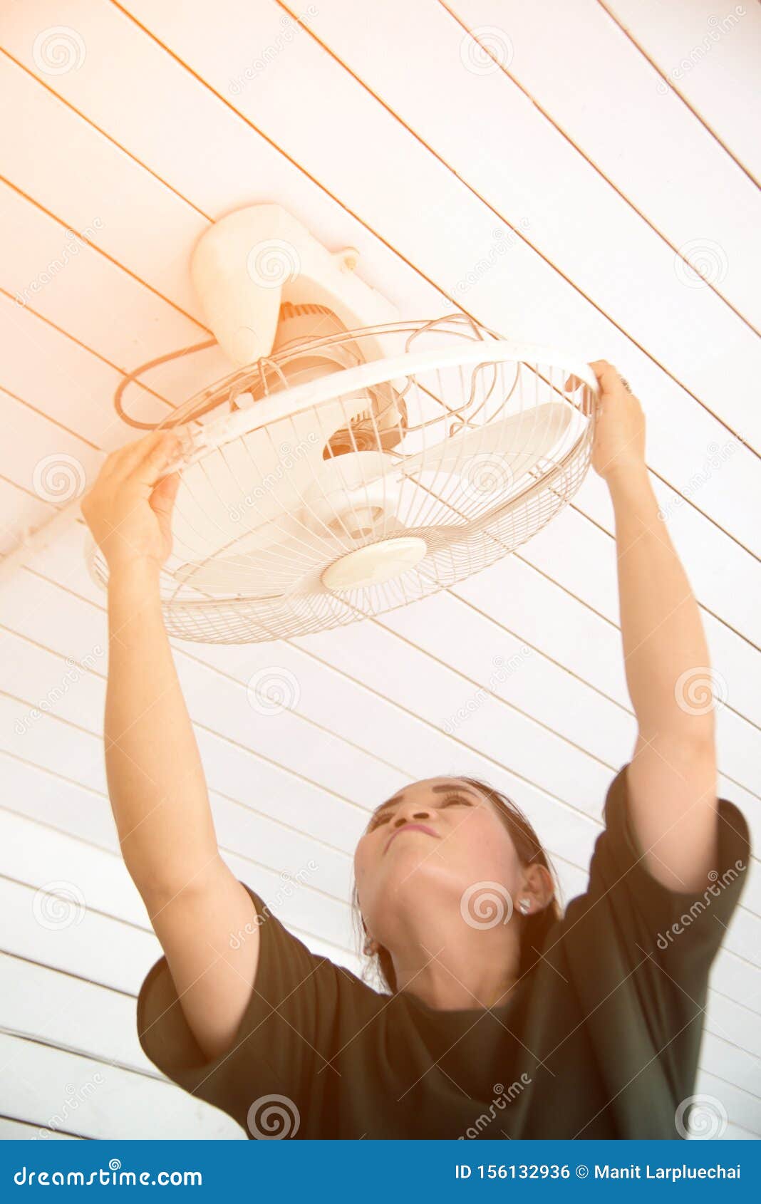 The Maidservant Is Installing And Cleaning The Ceiling Fan