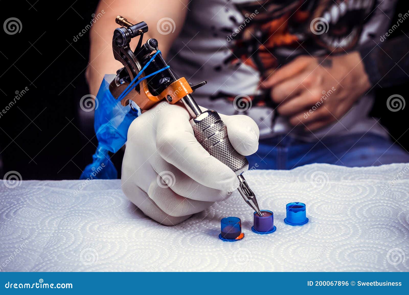 Main D'un Tatoueur Avec Une Machine à Tatouer./main D'un Tatoueur  Professionnel Et D'un Pistolet à Tatouer.