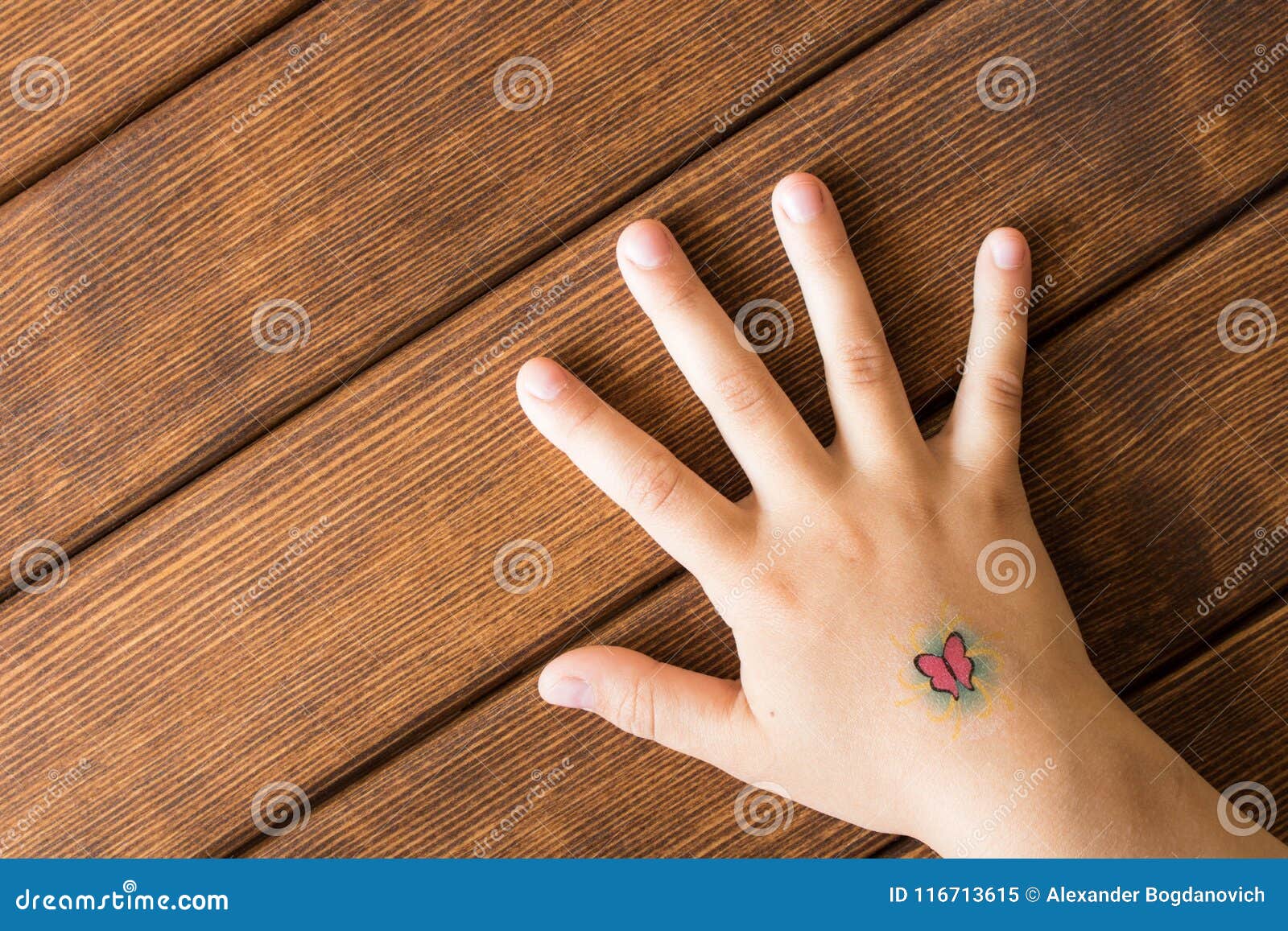 Main De Petite Fille Avec Le Tatouage De Bebe Sur Le Fond En Bois Image Stock Image Du Tony Mode