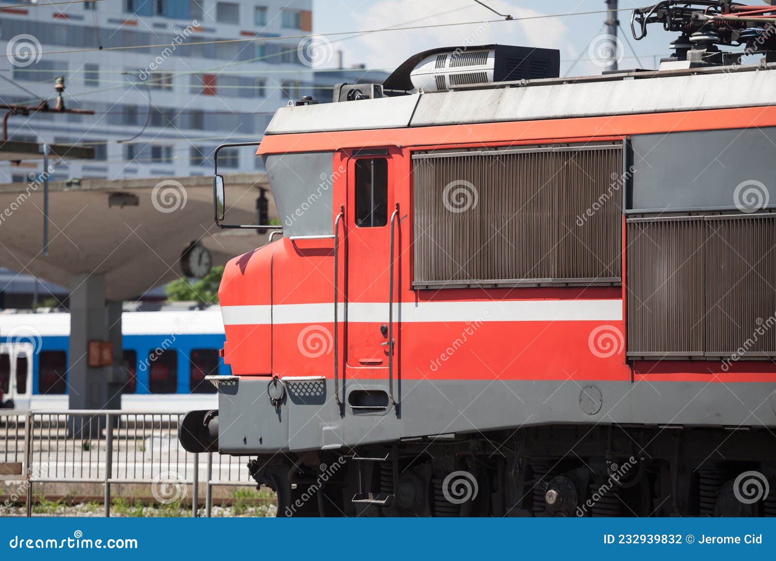 red electric locomotive of slovenian railways shunting on ljubljana train station platform getting ready for departure.