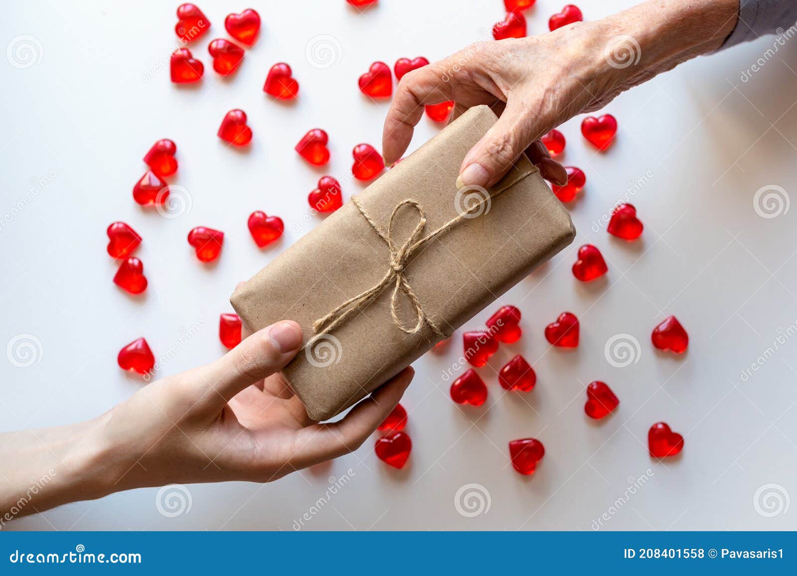 Mains D'un Jeune Homme Faire Un Cadeau à Une Vieille Femme. Petites Pierres  En Forme De Coeur Avec Un Cadeau Fait De Papier Artisa Photo stock - Image  du carte, émotion: 208401558