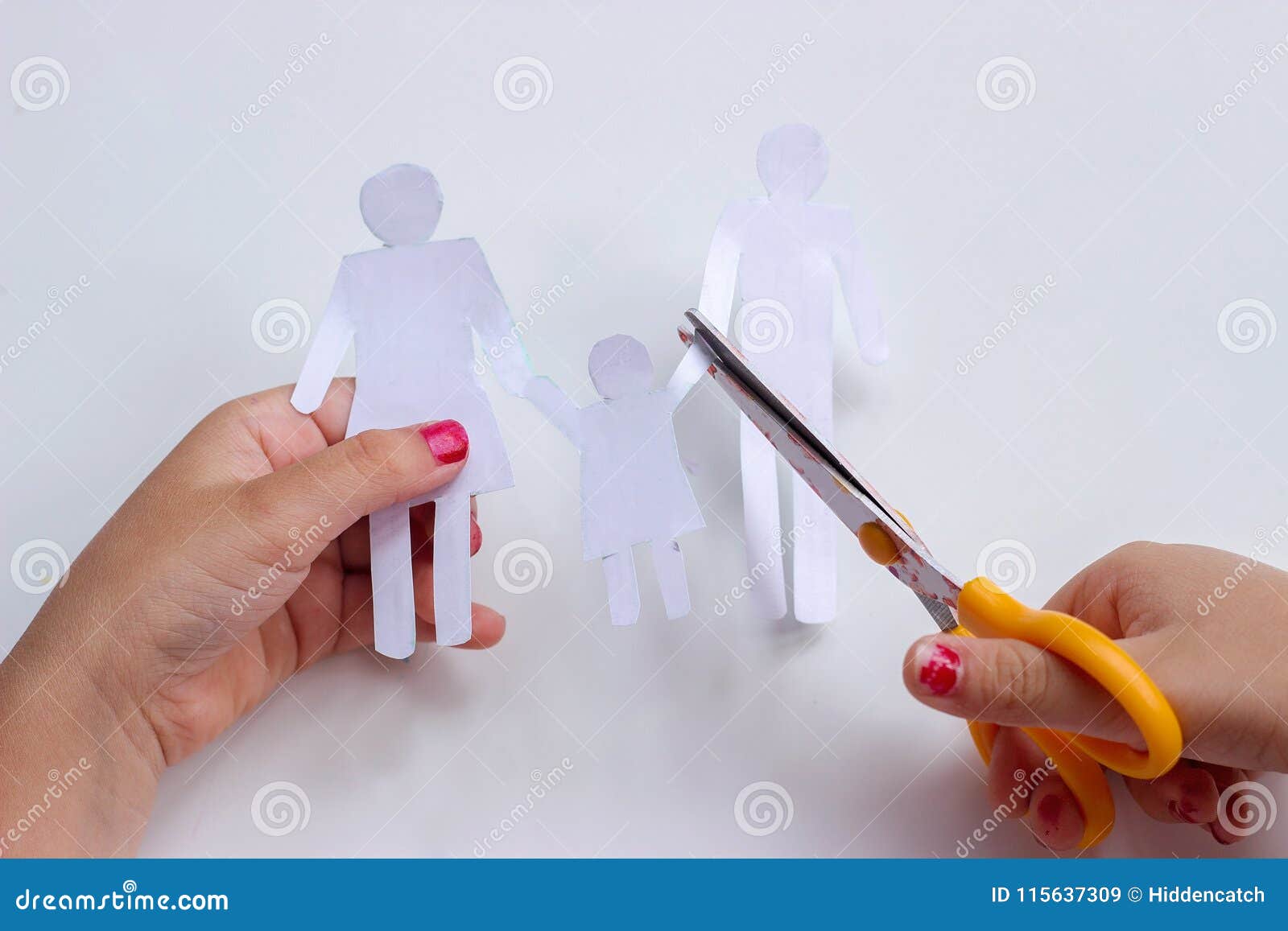 Mains d'une famille de chaîne de papier de coupe de petite fille avec des ciseaux ; concept cassé de famille ou de divorce