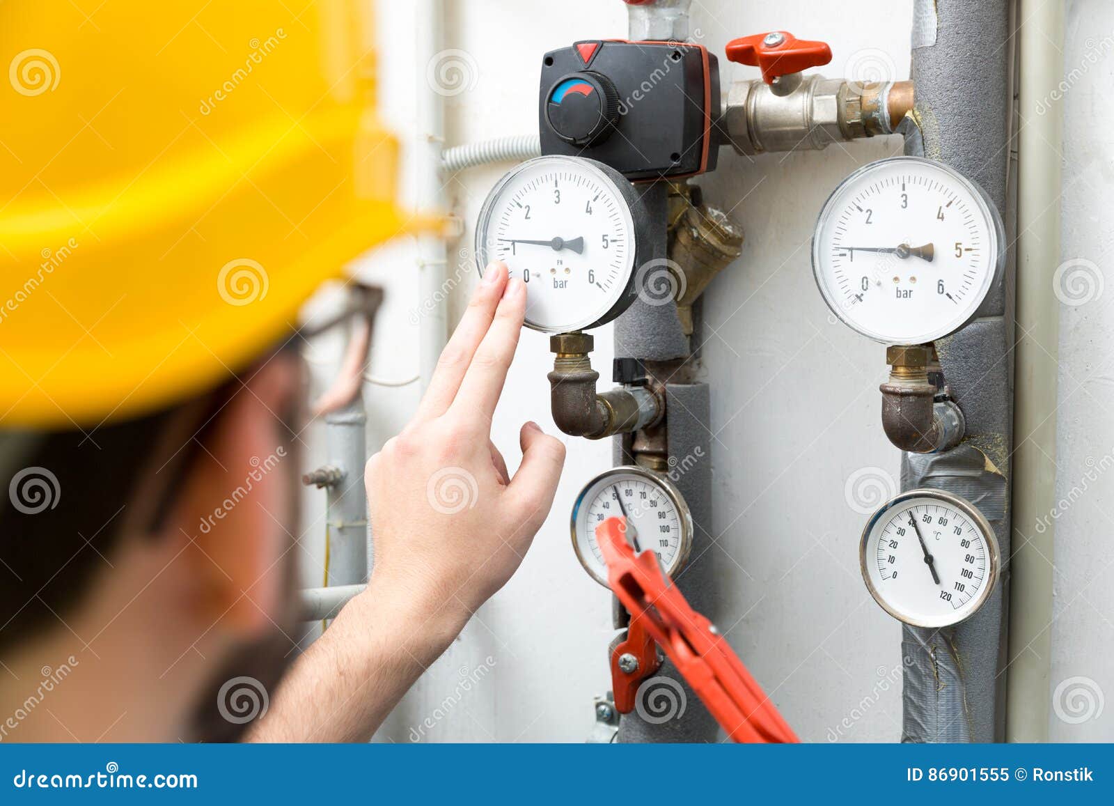 maintenance - technician checking heating pressure meters