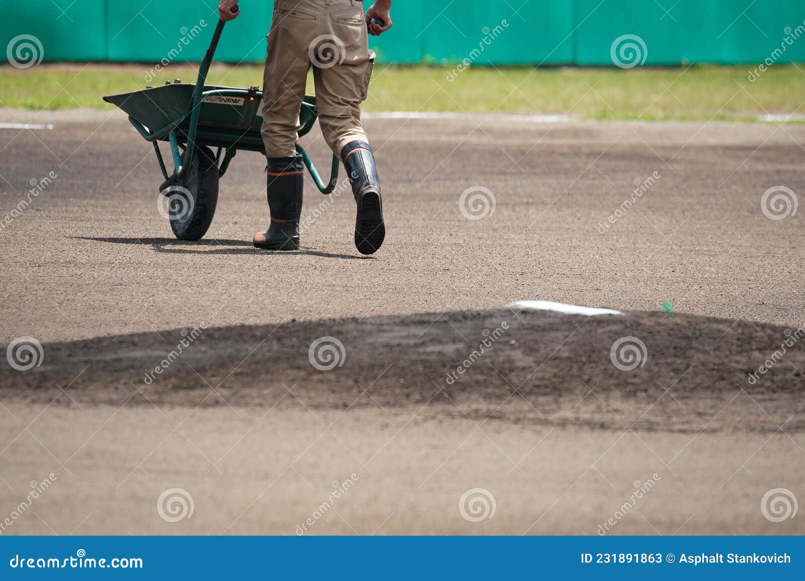 A Maintenance Worker Finishes Preparing the Mound on the Baseball Field