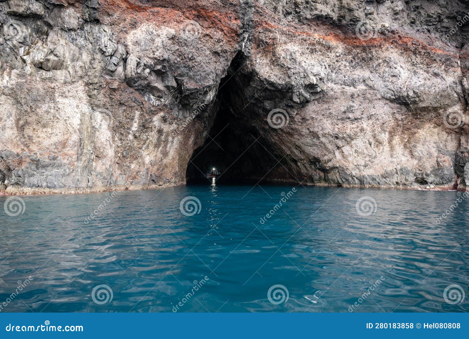 boat passes through the rock tunnel washed out by the surf, oki islands, shimane, japan, unesco global geopark.