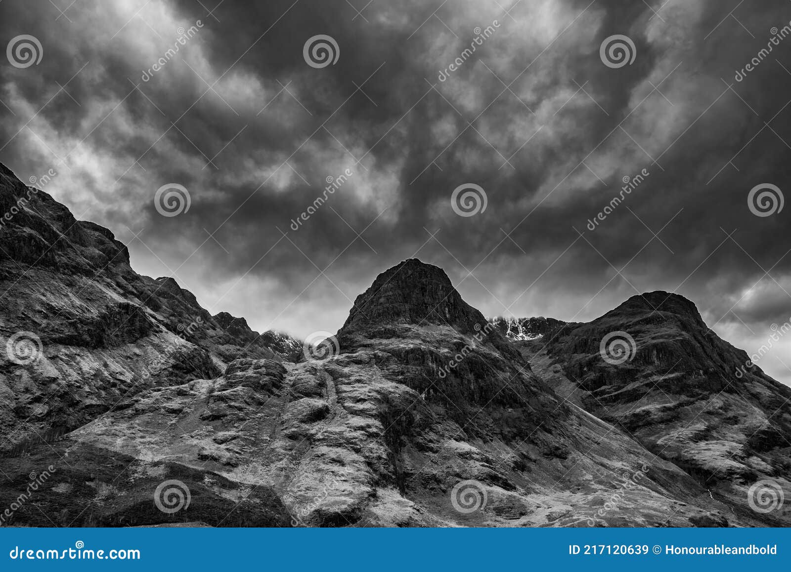 majestic moody  black and white landscape image of three sisters in glencoe in scottish highlands on a wet winter day wit high