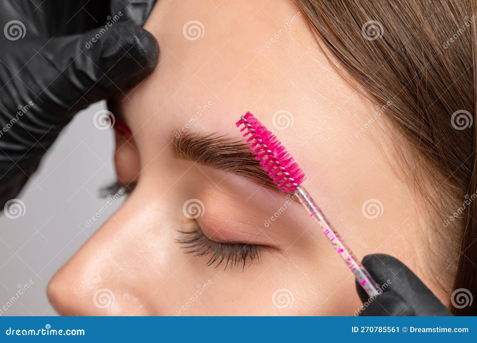 the make-up artist does long-lasting styling of the eyebrows of the eyebrows and will color the eyebrows. eyebrow lamination.