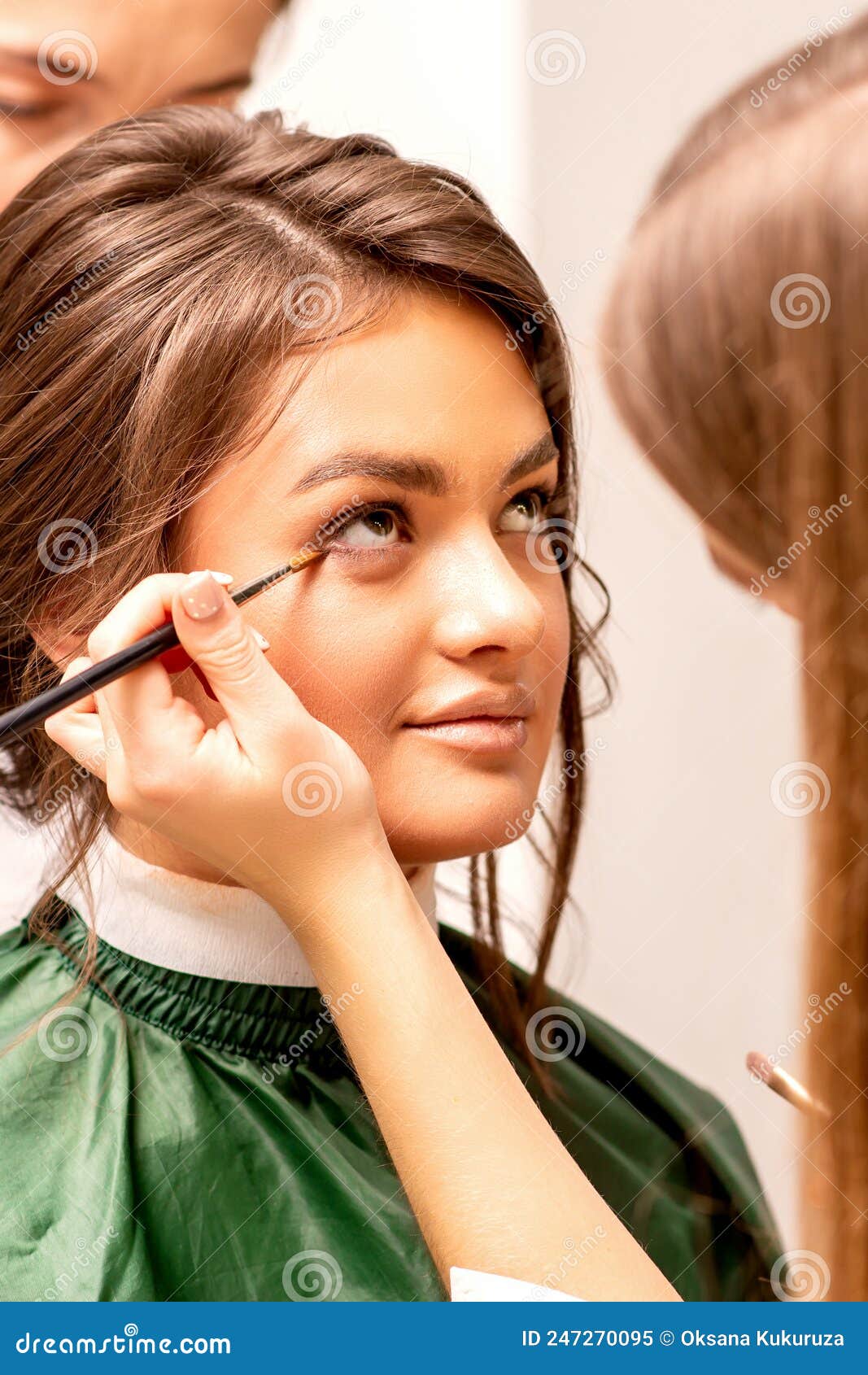 The Makeup Artist Applies a Concealer Under the Eyes Using a Makeup
