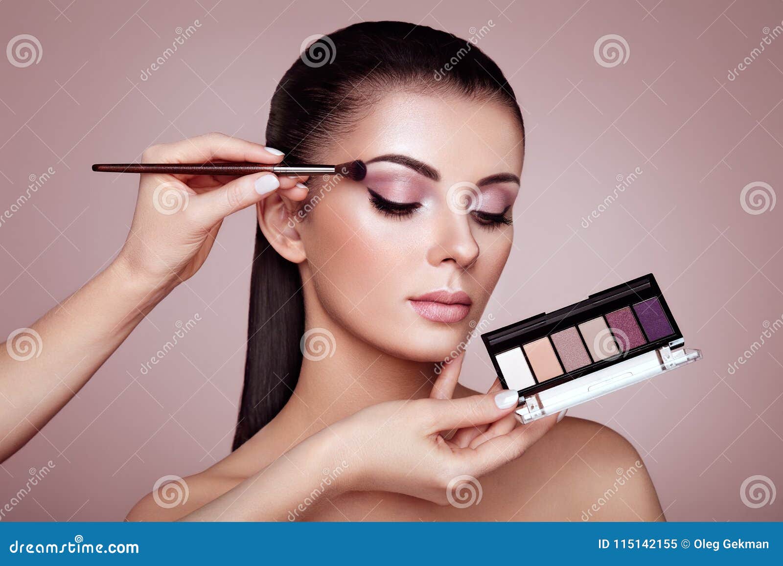 makeup artist applies eye shadow