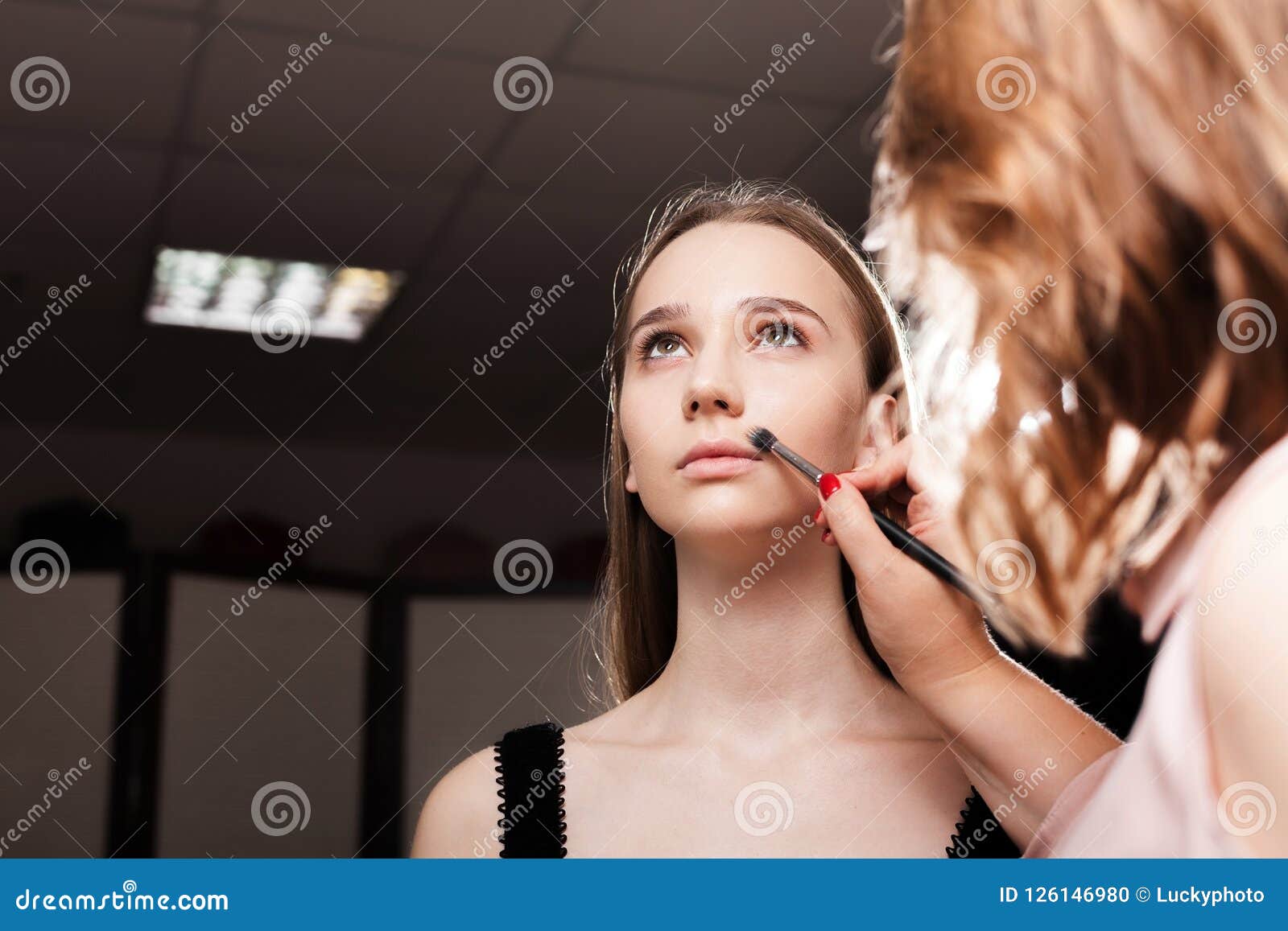 Makeup Artist Dabbing Foundation on a Client Stock Photo Image of