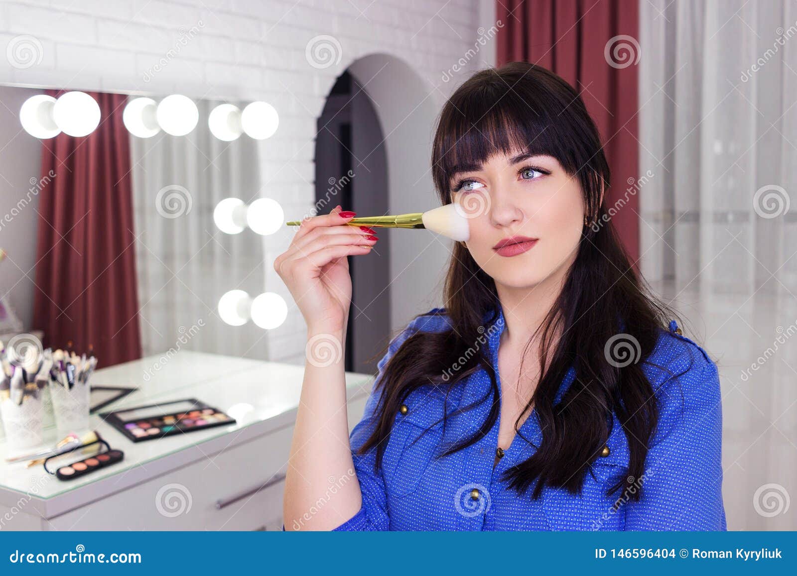 Makeup Artist Makes Makeup on Face with Makeup Brush Stock Photo