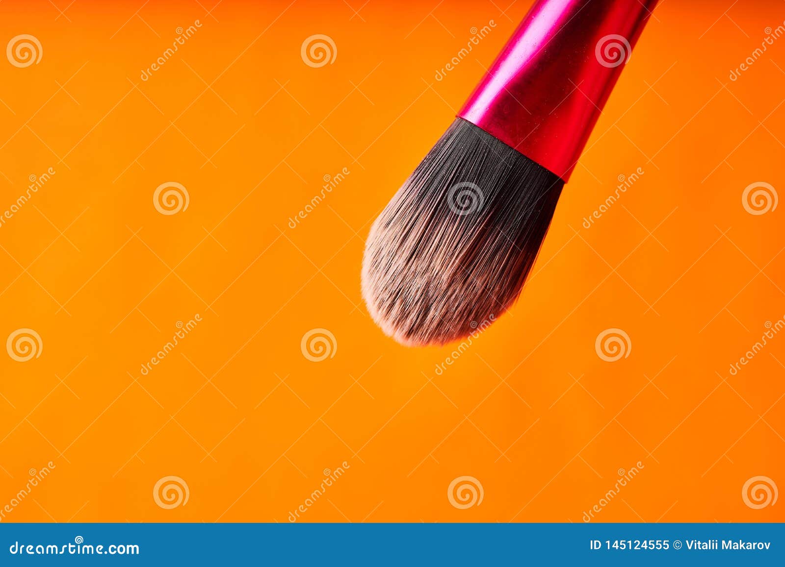 Makeup Brushes on Orange Background. Tools for Cosmetic Procedures