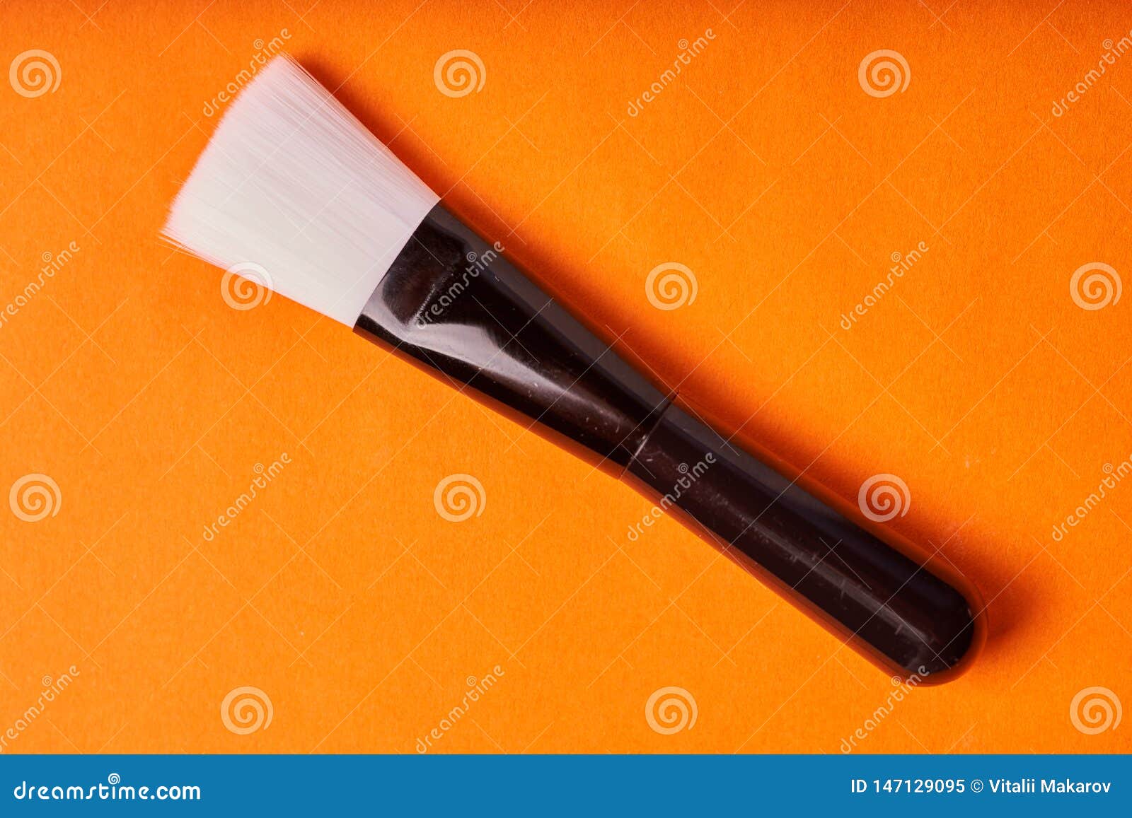 Makeup Brushes on Orange Background. Tools for Cosmetic Procedures