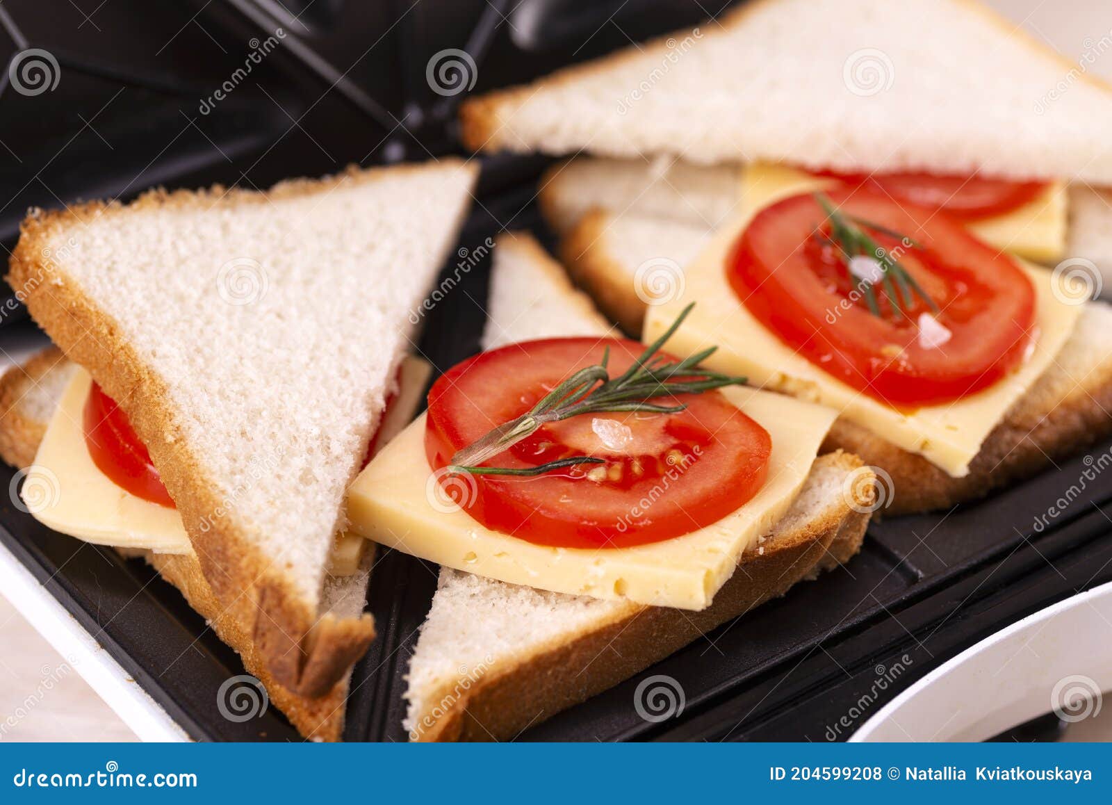 Making Cheese and Tomato Sandwiches on a Sandwich Press Stock Photo