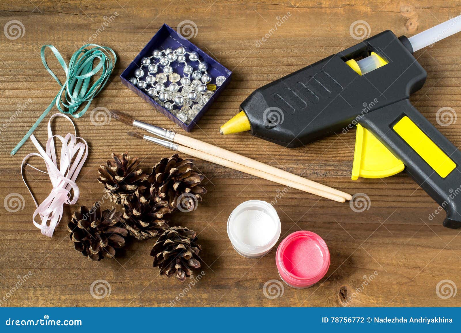 Woman glues pasta with a hot glue gun during the manufacture of crafts  Stock Photo
