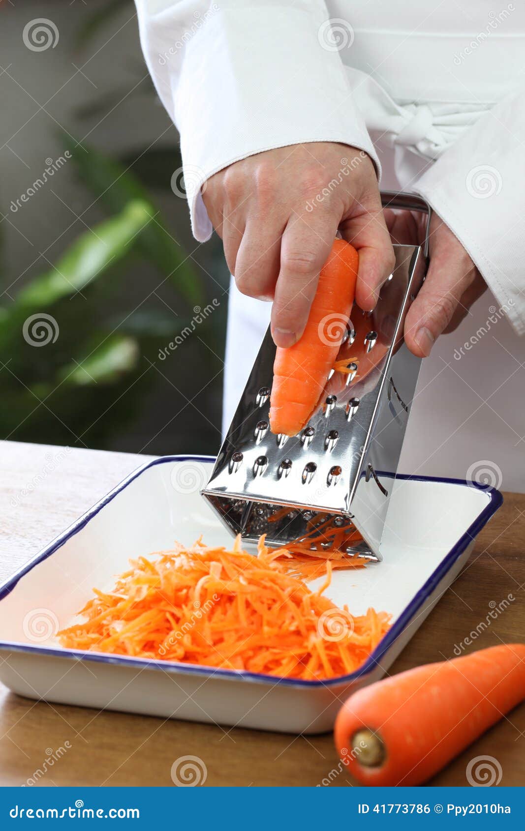 chef shredding carrots with grater in kitchen Stock Photo - Alamy