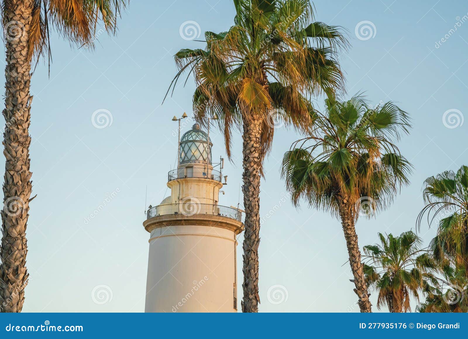 malaga lighthouse (la farola) and palm trees - malaga, andalusia, spain
