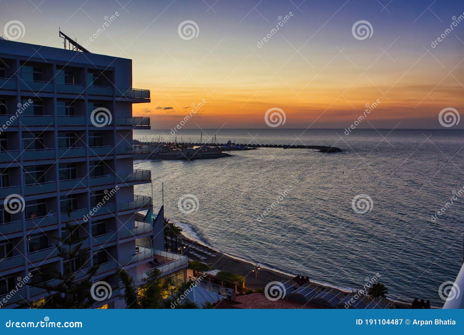 malaga, spain - september 02, 2015: dramatic sunset view of city architecture before beach seashore located in costa del sol