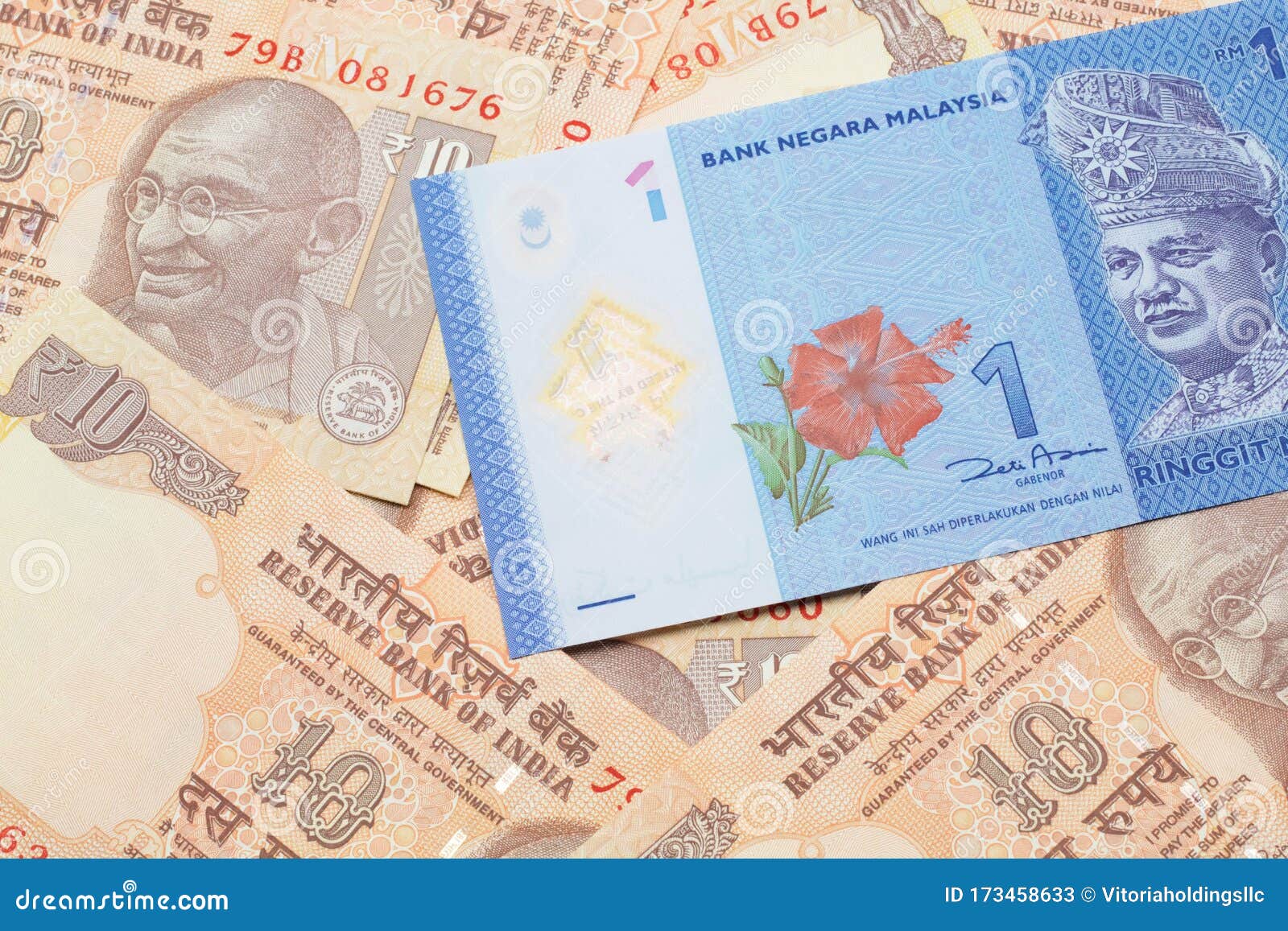 A Malaysian Ringgit on a Background of Indian Ten Rupee Bank Notes