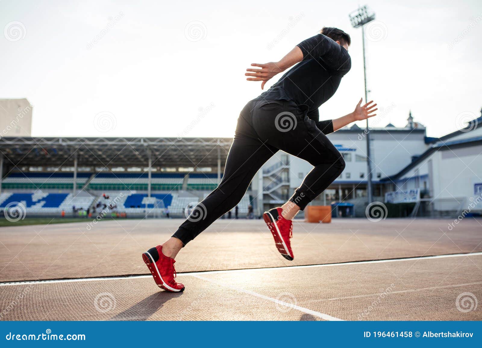 Athlete in Black Clothes Starting Sprint on Running Track Stock Photo ...