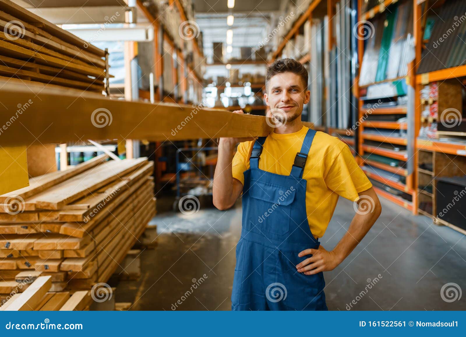 male builder holds wooden boards in hardware store